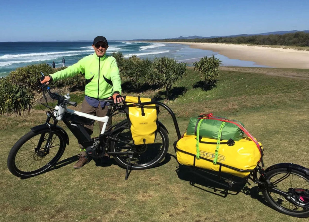 Riese & Müller Delite electric bike with panniers and loaded cargo trailer on a multi-day bikepacking trip