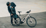 Person with a helmet and coat standing next to a Orbea Carpe 10 E Bike on a concrete surface. | Electric Bikes Brisbane