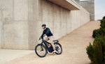Riese & Müller Delite5 full suspension eBike rider on urban path