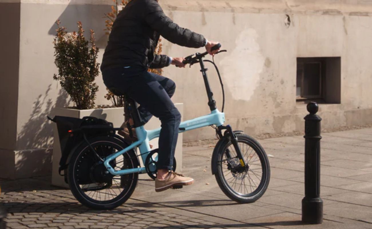 Person riding a turquoise electric bike in an urban setting | Electric Bikes Brisbane