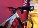 Close-up of Focus Sam2 6.0 e-mountain bike cockpit with One Up handlebar, SRAM AXS POD shifter and Bosch mini remote, with a red background