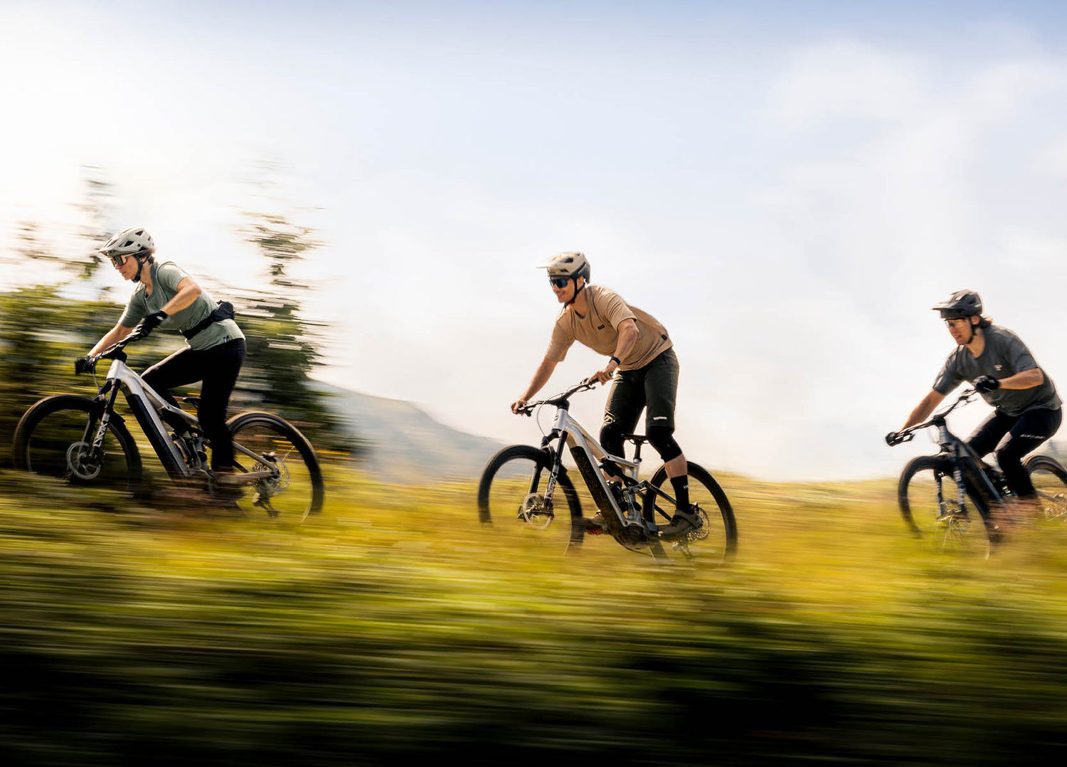 Three people riding fast down a mountain trail on Focus Jam2 electric mountain bikes