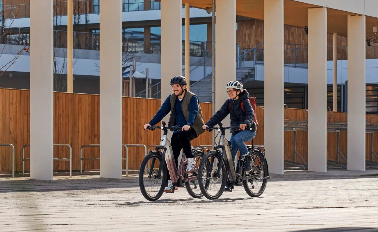 Focus Aventura2 FS 6.8 Wa E-Bike being ridden buy a man and women in a city setting | Electric Bikes Brisbane