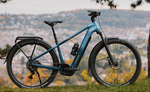 Focus F26 Aventura2 6.8 800Wh E-Bike on a grassy area with a scenic background