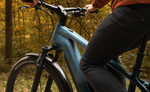 Person riding a Focus F26 Aventura2 6.8 800Wh E-Bike in a forest setting