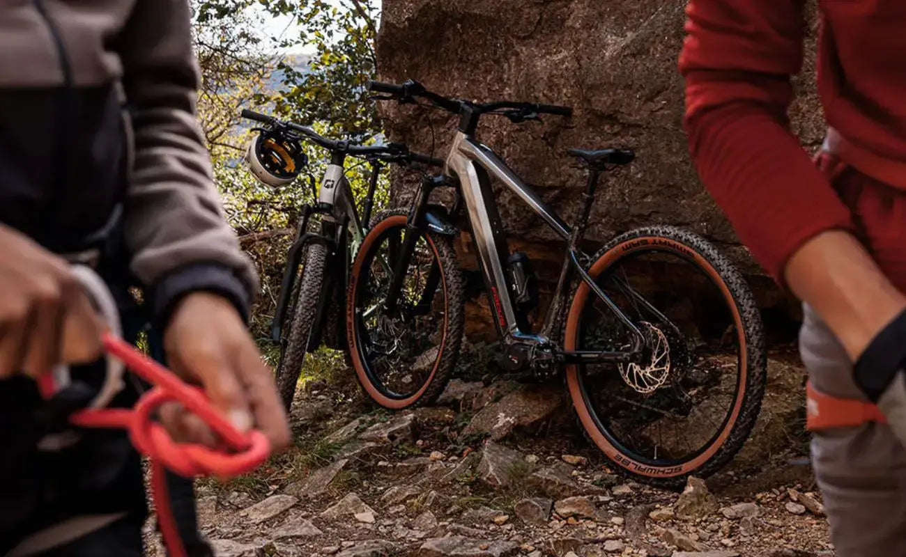 Two Focus F26 Jarifa2 6.7 Hardtail E-MTB on a rocky trail with two people partially visible | Electric Bikes Brisbane