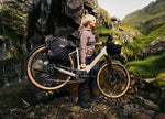 Lady carrying Kalkhoff L Entice EBike down a mountainous pathway
