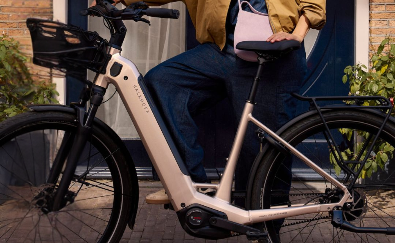 Person riding a Kalkhoff Entice 3 Excite Belt Wave EBike with a basket in an urban setting | Electric Bikes Brisbane