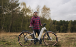 Man standing with a Kalkhoff K26 Entice 5+ Move Wave EBike, Moonstonegrey in a forested area