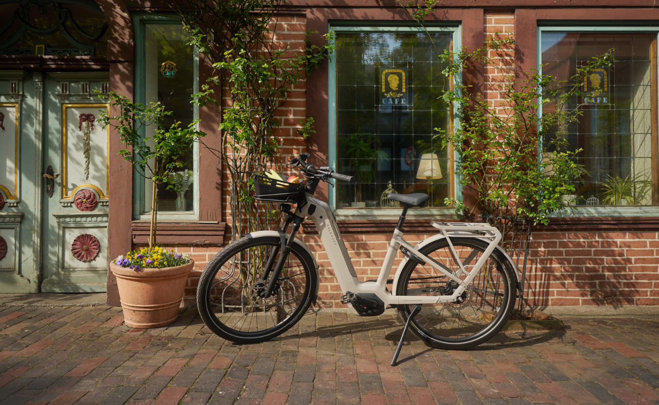 Kalkhoff K26 Image 5+ Advance Wave EBike parked in front of a brick building with decorative windows and plants. | Electric Bikes Brisbane