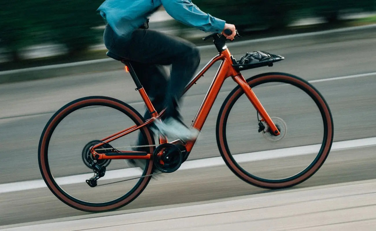 Person riding a Mars Red Carpe Ebike on a road with blurred background | Electric Bikes Brisbane