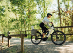 Lady riding an Orbea Muga electric bike on a path with trees in the background
