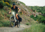 Lady riding an Orbea Muga electric bike climbing on a gravel trail 