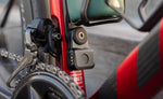 Quad Lock Bike Alarm and Finder secured below the bottle cage on a red road bike, beside the front derailleur.