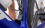 Quad Lock Bike Alarm and Finder with two green LEDs illuminated, mounted below a bottle cage on a blue bike.