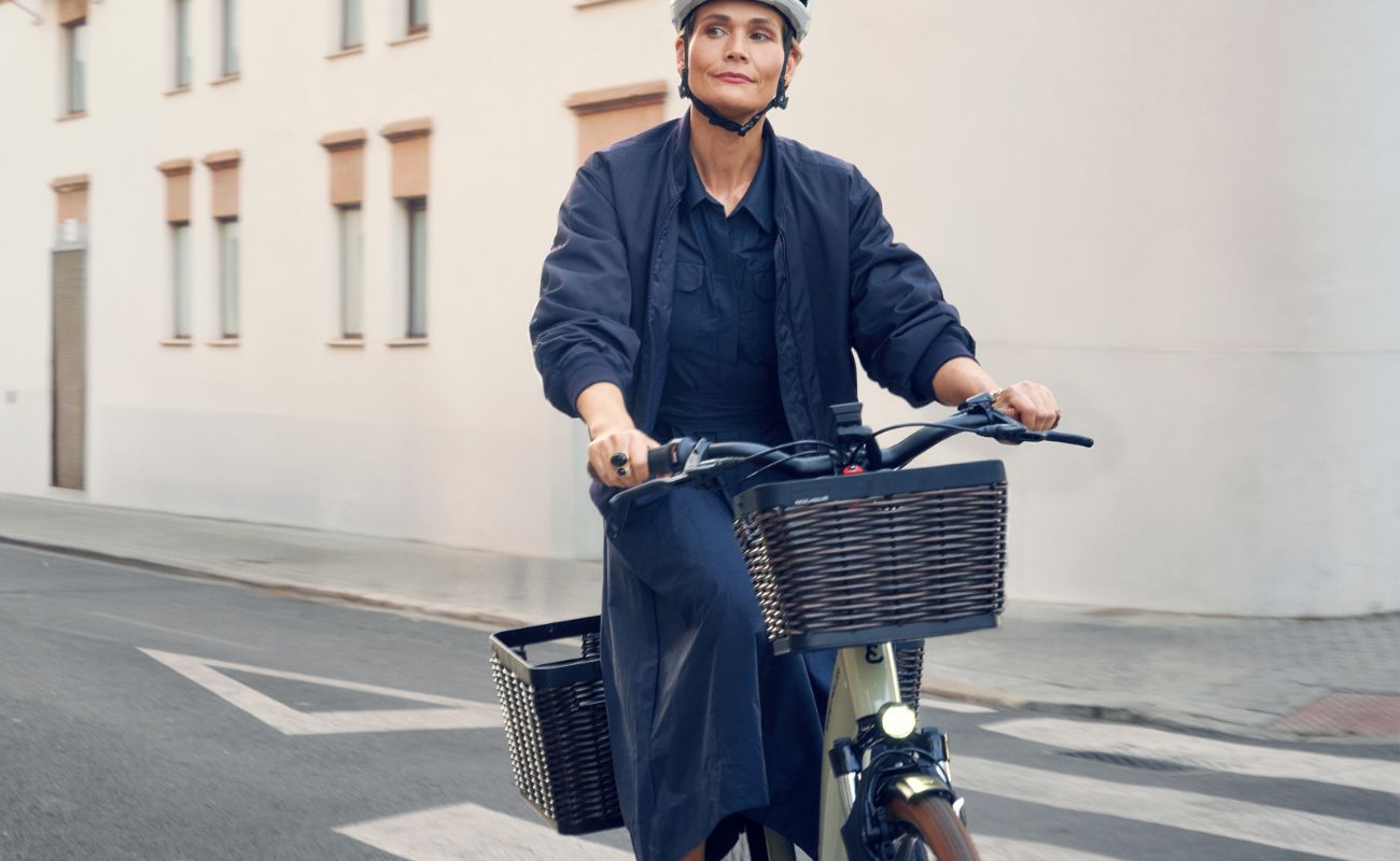 Rider on a Riese & Müller Swing5 electric bike with optional front and rear baskets on an urban street