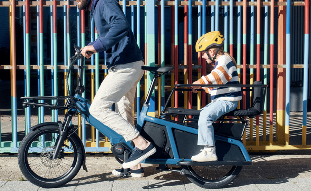 Parent and child riding on a Riese & Muller Multitinker with the Family Kit