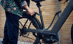 Riese & Muller Nevo5 Vario Core E-Bike Slate Grey Variant Locked by the pole | Electric Bikes Brisbane