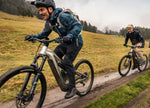 Two people enjoying riding downhill on a wet muddy trail on the F26 Focus Thron2 6.8 ABS electric mountain bike