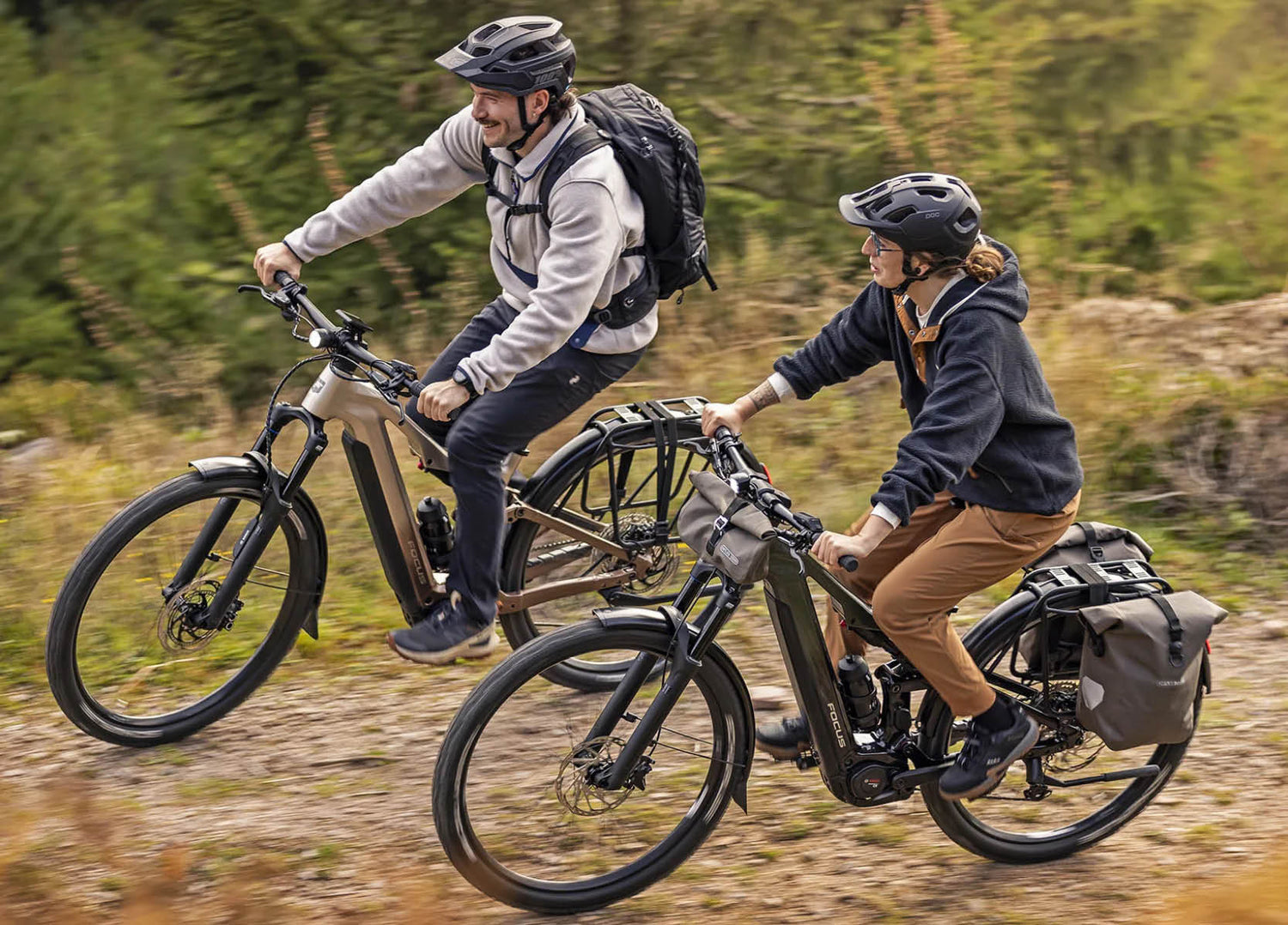 Two people riding equipped F26 Focus Thron2 electric bikes on a stony mountain trail. 